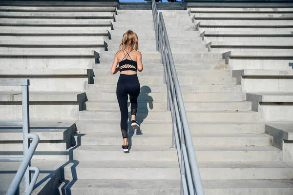Mujer corriendo ejercicio concepto de bienestar. Estilo de vida saludable, joven chica deportiva fitness corriendo por las escaleras de piedra . — Foto de Stock