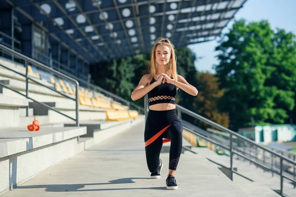 Junge sportliche Frau macht Übungen mit Gummiband im Freien — Stockfoto