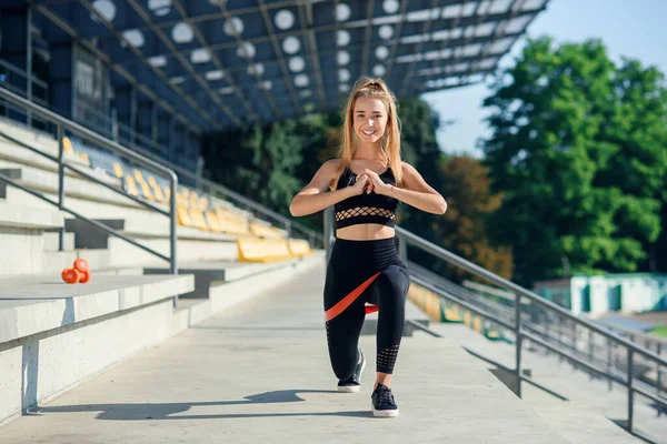 Junge sportliche Frau macht Übungen mit Gummiband im Freien — Stockfoto