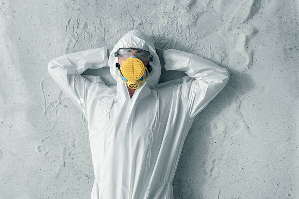 Мужчина в белой защитной форме, респираторе и пластиковых прозрачных очках
.