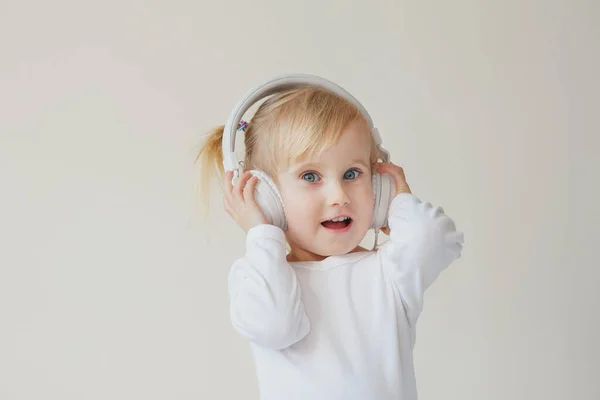 stock image home, technology and music concept - little girl with headphones listening to music and singing