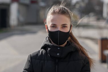 Şehirdeki hava kirliliği ya da virüs salgını yüzünden maske takan bir kadın.