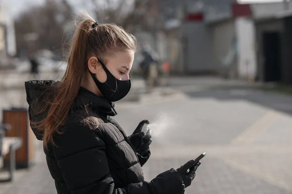 A mão da mulher está pulverizando álcool, spray desinfetante no telefone celular, prevenir a infecção do vírus Covid-19, contaminação de germes ou bactérias, limpar ou limpar o telefone para eliminar, surto de Coronavirus — Fotografia de Stock