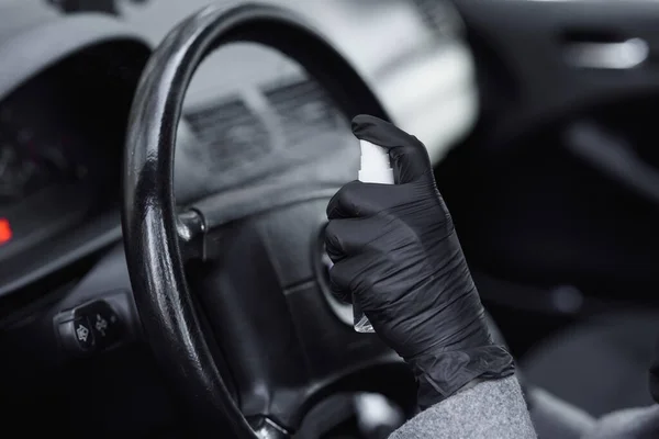 Az autó belsejének tisztítása és fertőtlenítő folyadékkal való permetezés. Kezek gumikesztyűben fertőtlenítő vihicula belül a vírusbetegség elleni védelem érdekében — Stock Fotó