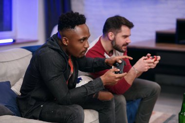 Yavaş hareket eden, heyecanlı, eğlenceli, çoklu etnik kökenli çocuklar. Evde video oyunu oynarken birbirleriyle oynuyorlar. Sakallı bir adam zaferi kutluyor, ikincisi kaybediyor.