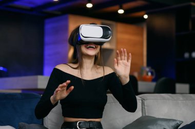 Video kayıt cihazı. Sanal gerçeklik kulaklığı kullanan heyecanlı milenyum kızı içeride video oyunu oynuyor. Seçici Odaklanma