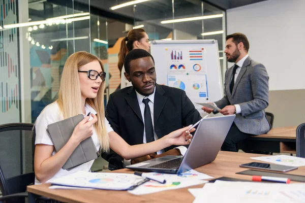 Compañeros amistosos están discutiendo su plan de negocios conjunto durante la jornada laboral . — Foto de Stock