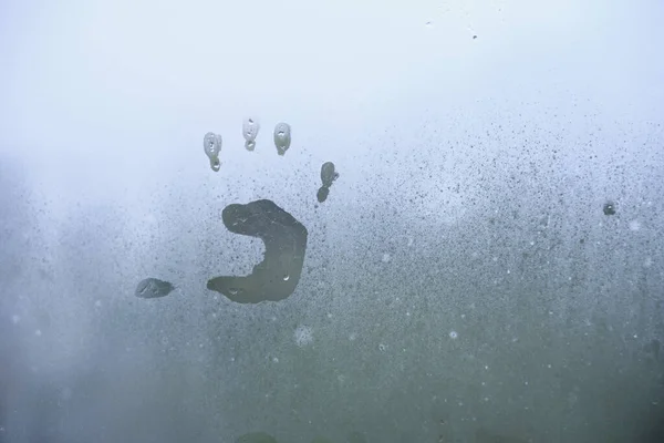 Pequenas crianças handprint em vidro chuvoso nebuloso . — Fotografia de Stock