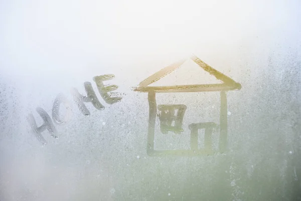 Maison peinte sur verre embrumé. Vitre vitrée avec gouttes de pluie contre un ciel bleu et le soleil. Imitation de dessins pour enfants . — Photo