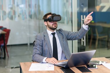 Ofiste video gözlük takan mavi takım elbiseli beyaz sakallı genç bir işadamı..