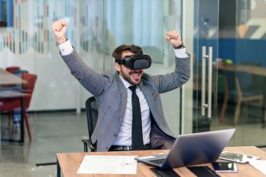 Sanal 3 boyutlu gözlüklü, özgüvenli, kendine güvenen profesyonel iş adamının yavaş hareket etmesi hayali ekrandaki iyi sonuçtan mutlu.