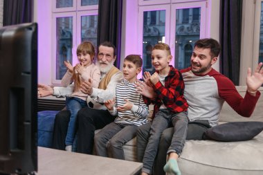 Mutlu, dost canlısı bir aile futbol maçı izler, evdeki kanepede şampiyonluk maçı izlerdi. Favori milli takım için duygusal tezahüratlar. Babam, büyükbabam ve torunlarım. Spor, TV, eğlence..