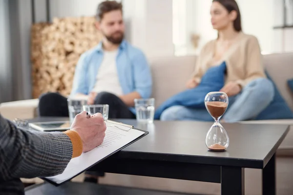 Annoyed caucasian couple of man and woman having conversation with psychologist on therapy session in light room. — Stock Photo, Image