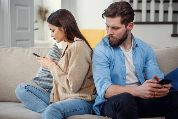 Porträtt av unga par står tillbaka till varandra och tittar på telefonen. — Stockfoto