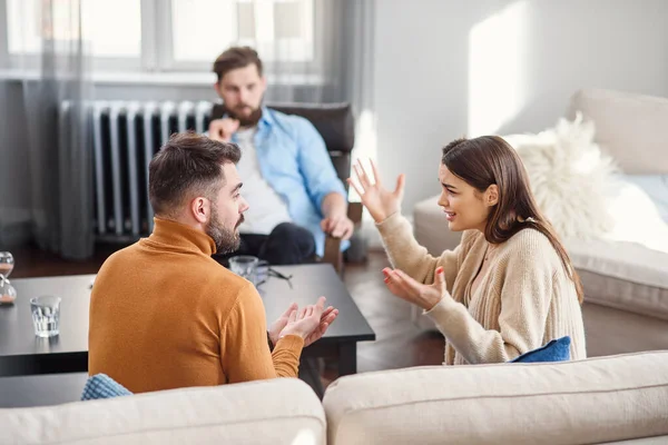 Young fighting angry couple blaming each other for problems, telling its your fault, discussing with psychologist who is right and wrong, misunderstanding and selfishness in marriage. — Stock Photo, Image