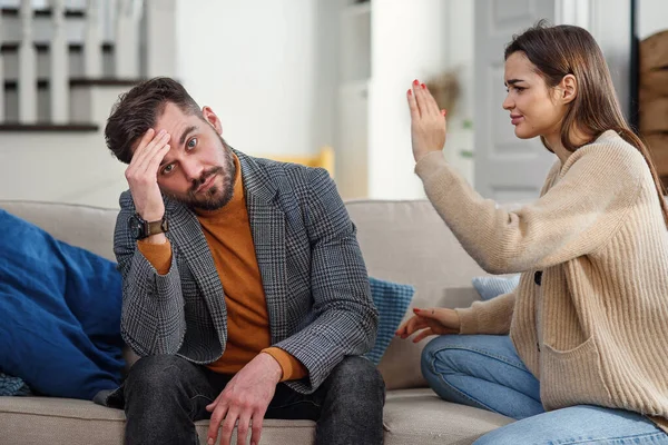 Zenuwachtige jongeman probeert te doesnt luisteren naar zijn vriendin in de slaapkamer. — Stockfoto