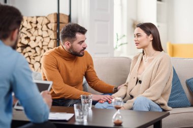 Genç, sevgi dolu eş psikoterapi seansında kocasına destek oluyor.