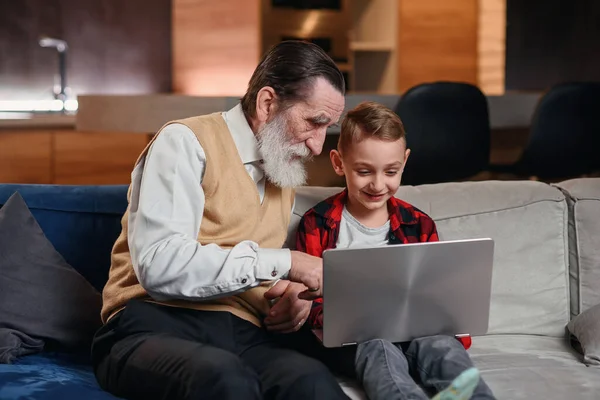 El nieto está enseñando a su abuelo a usar la computadora portátil . —  Fotos de Stock