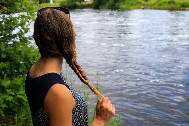 Bir nehir tarafından örgülü saçlı kız