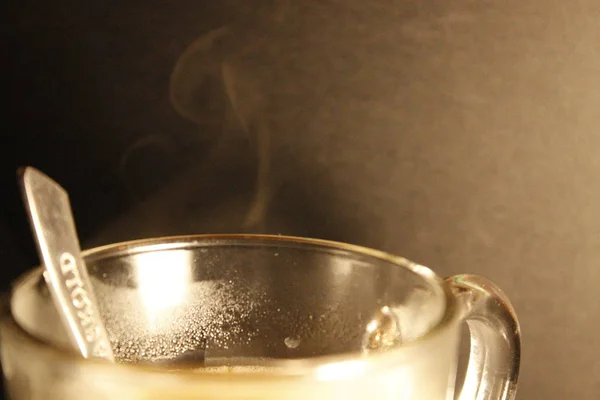 Bir fincan sıcak kahve onun yakın çekim bir kaşık ile