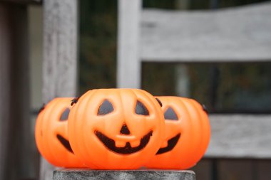 Üç turuncu Jack-O-Lantern üzerinde ahşap Bank