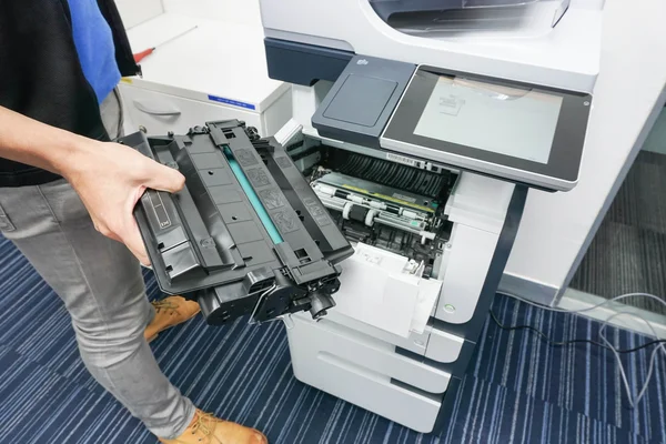 Бизнесмен держит картридж с чернилами, чтобы поместить его в принтер — стоковое фото