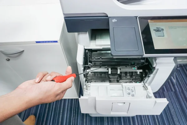 Homem com chave de fenda na impressora de fixação manual — Fotografia de Stock