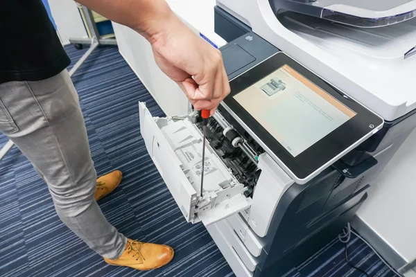 Техника починит принтер отверткой — стоковое фото