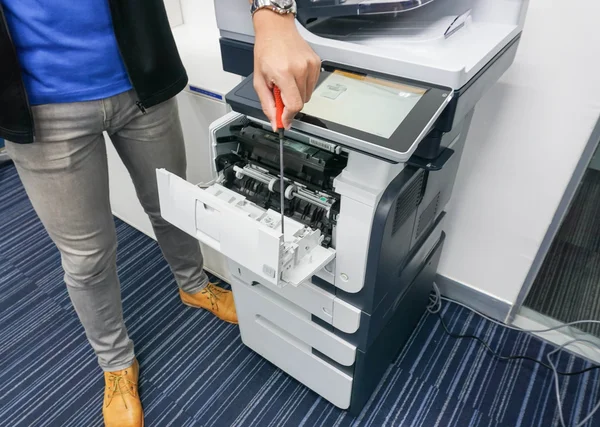 技术人员用螺丝刀修理打印机 — 图库照片