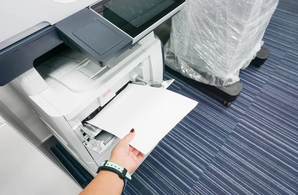 Woman wearing watch put stack of paper into printer for documents — Stock Photo, Image