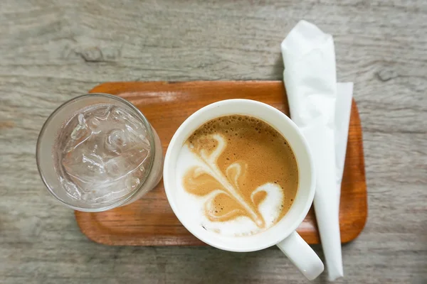 Conjunto de café quente com leite fluído e uma camada leve de espuma na bandeja de madeira — Fotografia de Stock