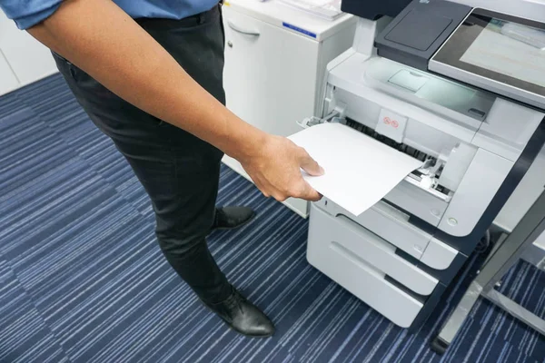 Un hombre está imprimiendo un documento y copiándolo — Foto de Stock