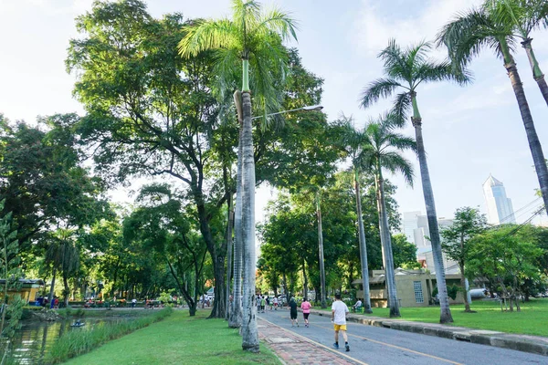 As pessoas fazem jogging em um parque da cidade depois do trabalho — Fotografia de Stock