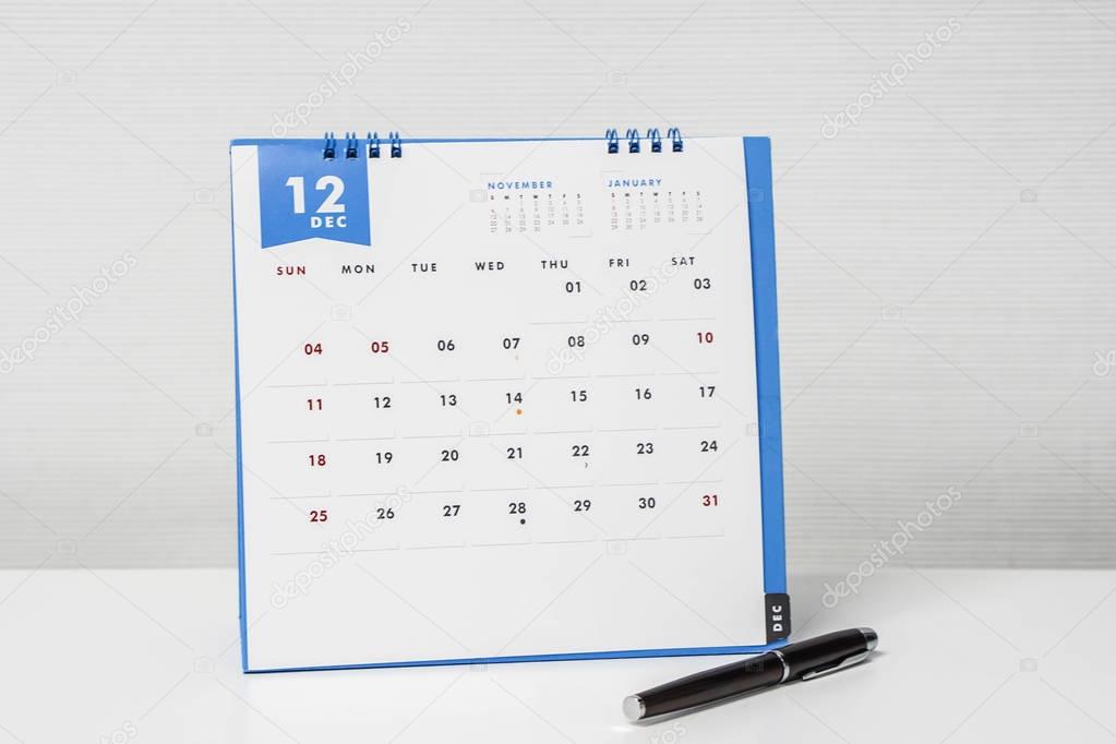 December calendar with pen on office desk