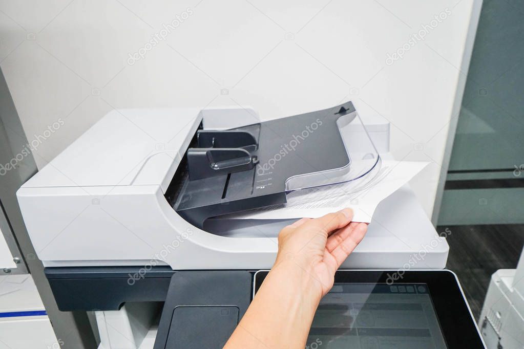 woman bring printed documents from printer machine with left han