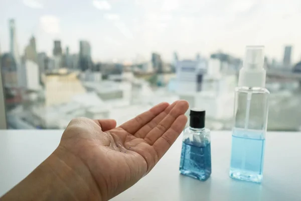 Alcohol bottle and anti-bacterial hand gel on woman left hand — Stock Photo, Image