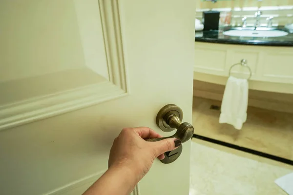 Mulher segurar maçaneta da porta para entrar no banheiro — Fotografia de Stock