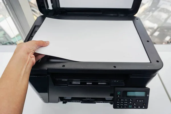 Женщина кладет лист бумаги на стеклянную пластину принтера для сканирования — стоковое фото