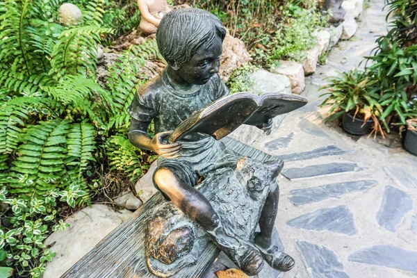 태국에서 정원에서 책을 가진 소년의 청동 조각 — 스톡 사진