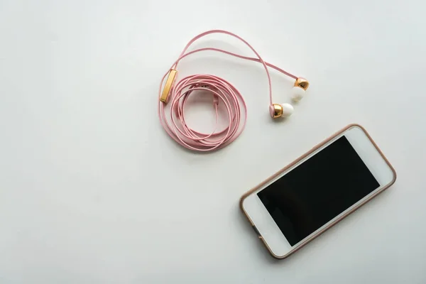 Teléfono inteligente aislado con auriculares rosa —  Fotos de Stock