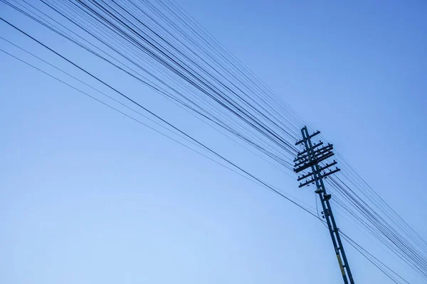 Electricity post with wire in clear blue sky — Stock Photo, Image