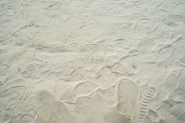 Fußabdrücke von Menschen auf weichem Sand am Strand — Stockfoto