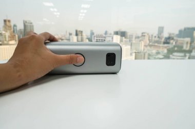 office programında müzik dinlemek için kadın el ile taşınabilir bluetooth sözcü yukarıya kapatmak