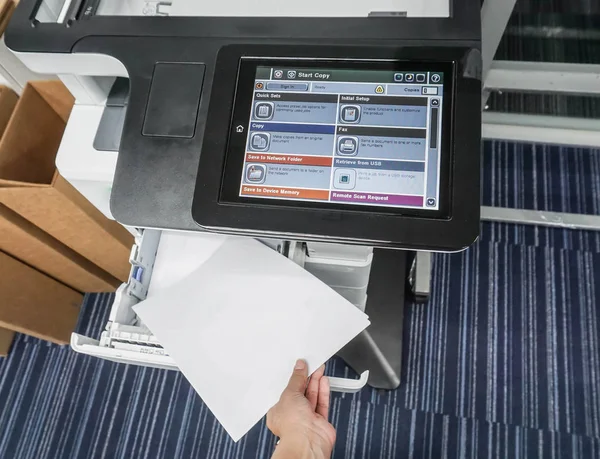 Chiuda l'uomo d'affari tira documenti da macchina di stampante multifunzione in ufficio — Foto Stock