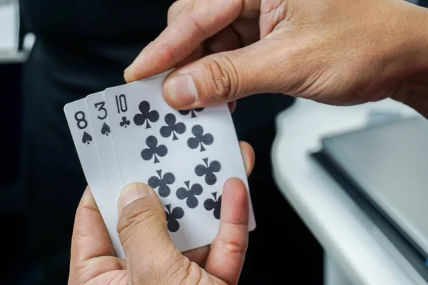 close up man play poker card in hands for gambling