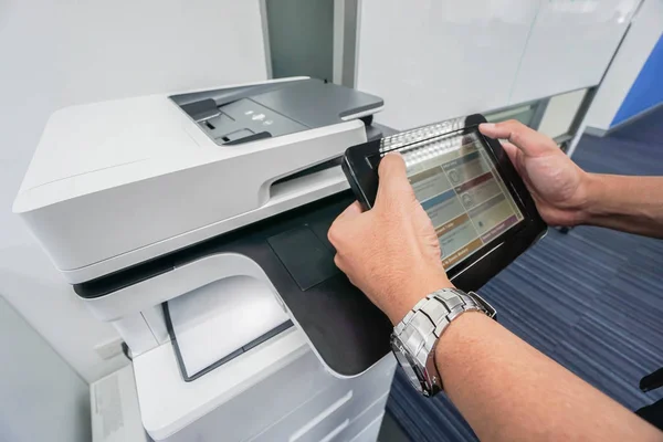 Homem de negócios segurar tela sensível ao toque para imprimir documento da máquina de impressora de escritório — Fotografia de Stock