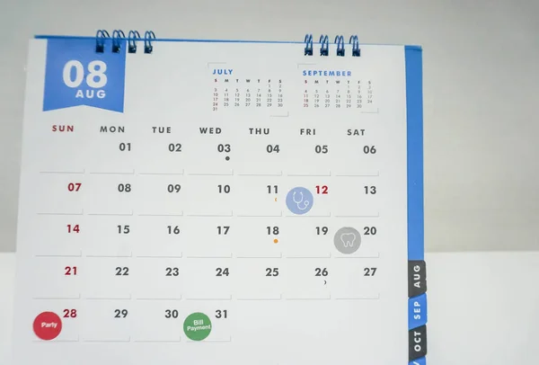 Крупним планом зустріч людей за серпневим календарем для оплати медичних рахунків — стокове фото