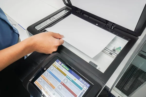 Geschäftsmann im blauen Hemd legt Papierbogen auf Druckerscanner — Stockfoto