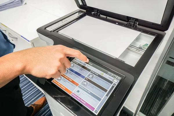 Hombre de negocios en camisa azul trabajar con el panel táctil de la impresora para el escaneo de documentos —  Fotos de Stock