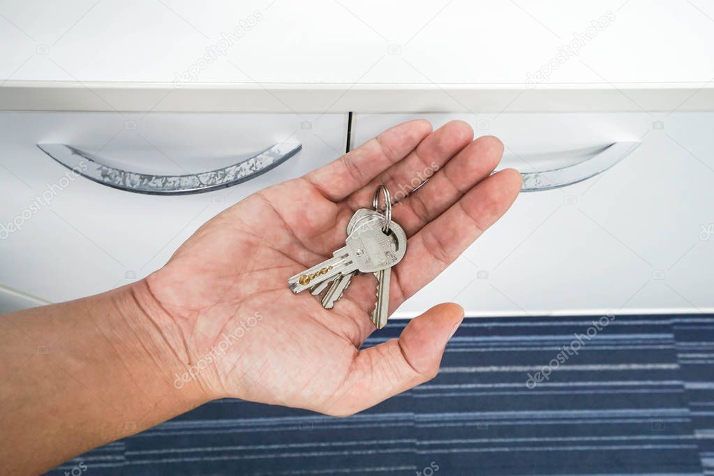 close up man hold key to unlock office drawer